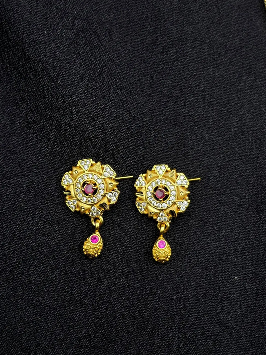 Gold earrings with gemstones on a black background