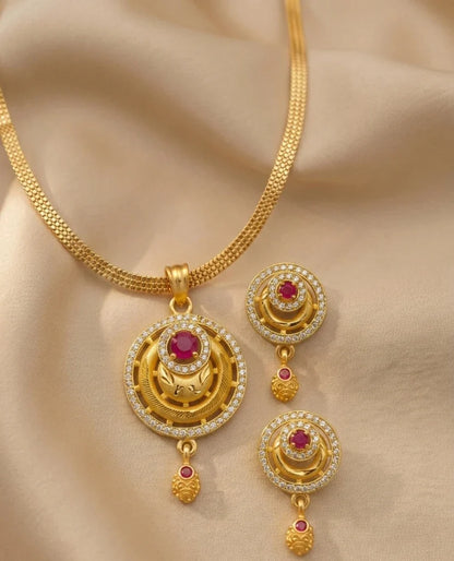 Gold necklace with matching earrings on a beige fabric background