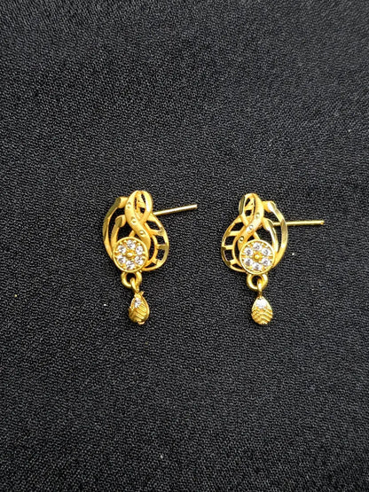 Gold earrings with intricate designs on a black background
