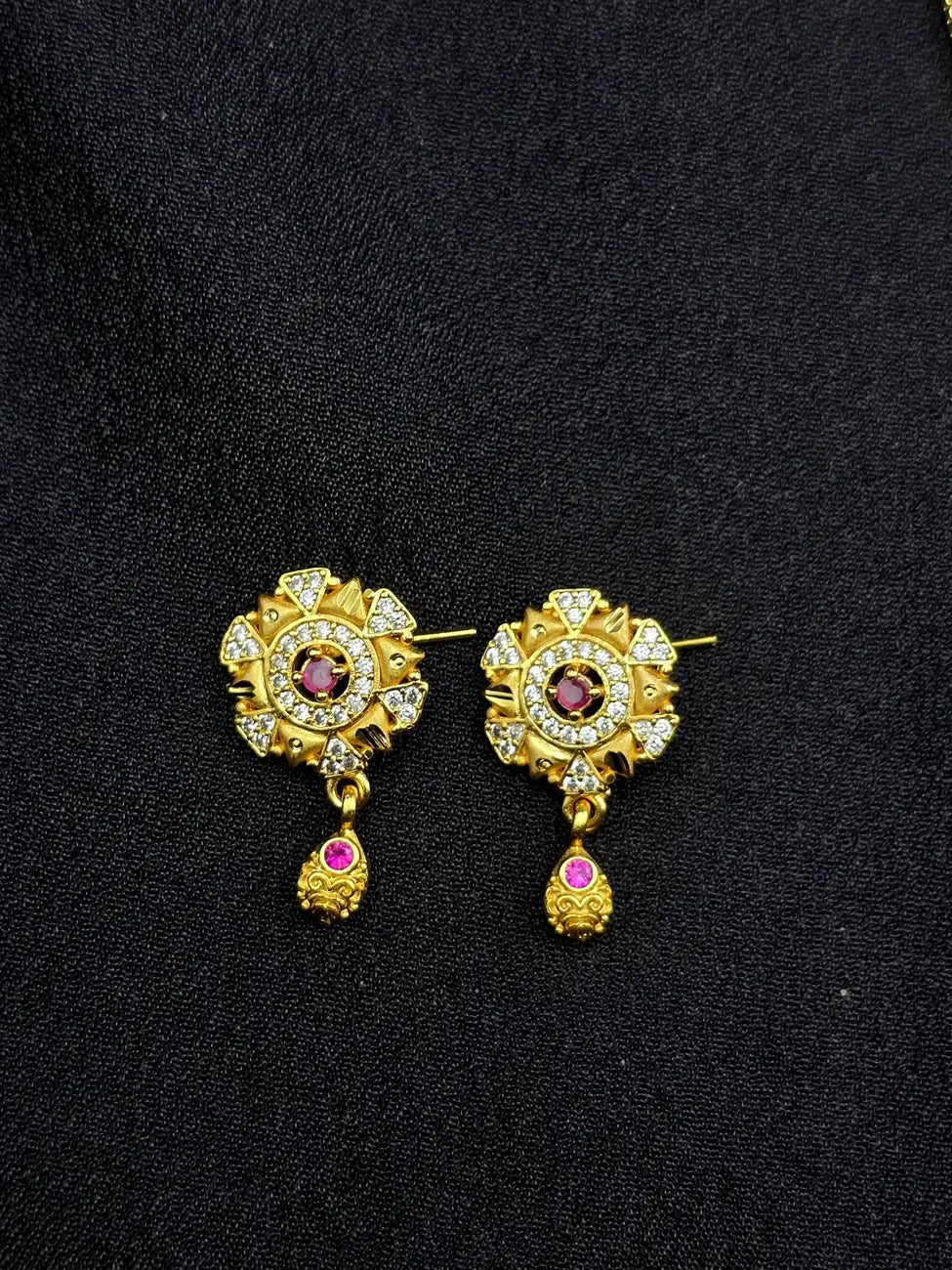 Gold earrings with gemstones on a black background