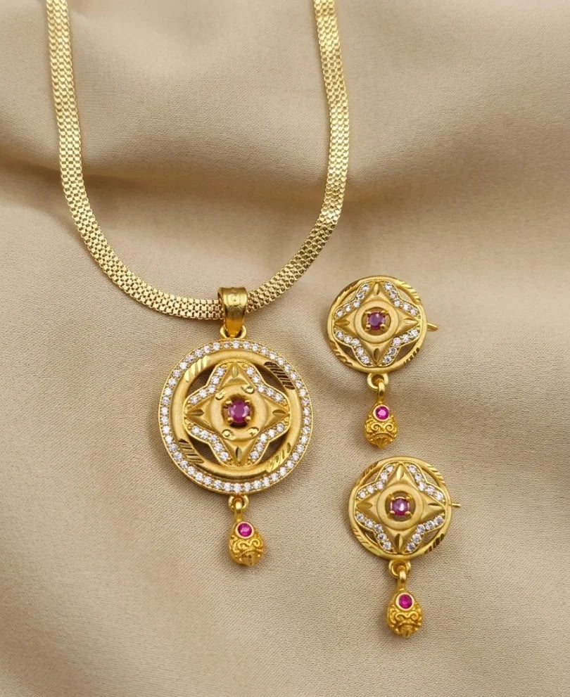 Gold necklace with matching earrings on a beige background