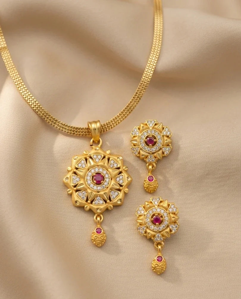 Gold necklace with matching earrings on a beige fabric background