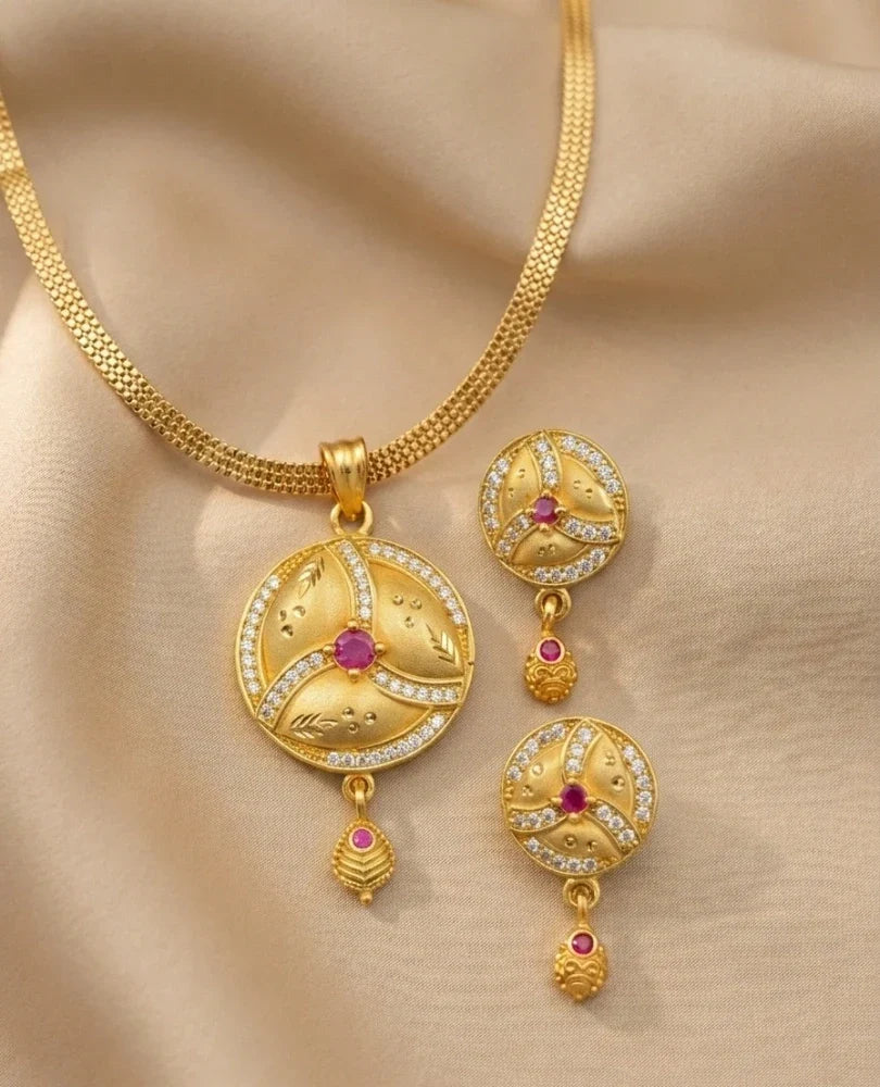 Gold necklace with matching earrings on a beige background