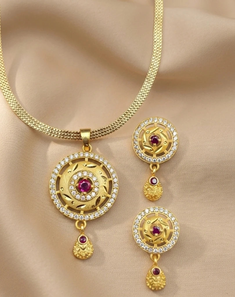 Gold necklace with matching earrings on a beige fabric background