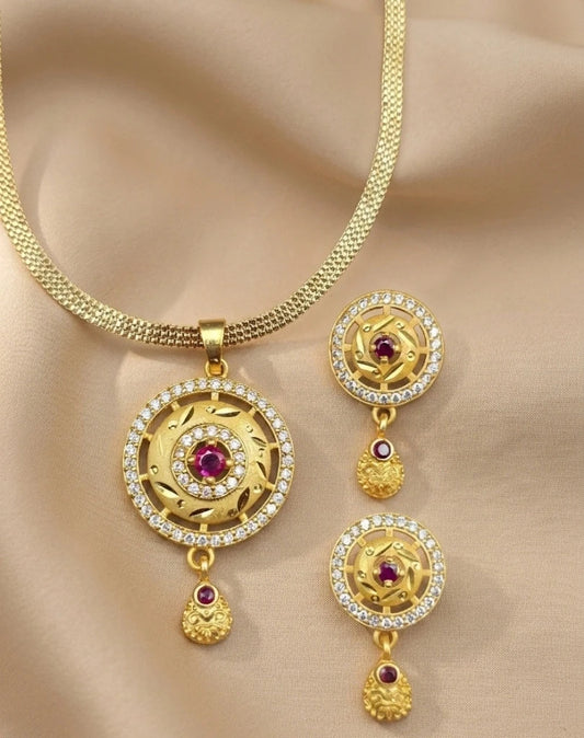 Gold necklace with matching earrings on a beige fabric background