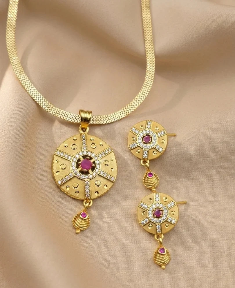 Gold necklace with matching earrings on a beige fabric background