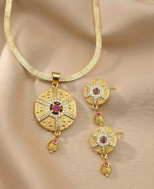 Gold necklace with matching earrings on a beige fabric background