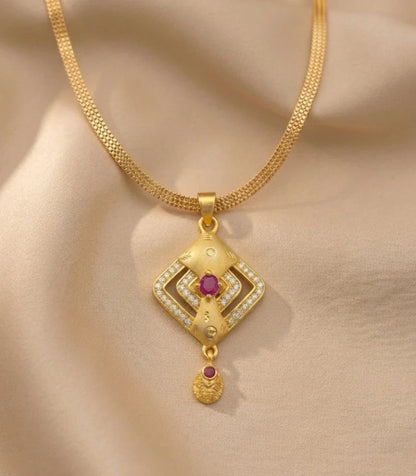 Gold necklace with a diamond-shaped pendant on a beige fabric background