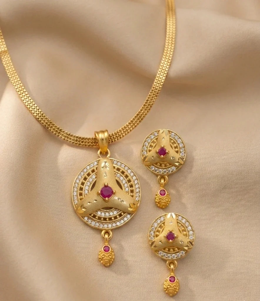 Gold necklace with matching earrings on a beige fabric background