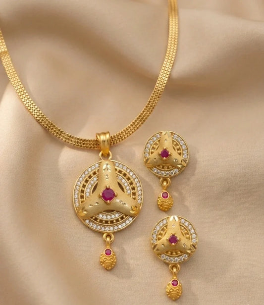 Gold necklace with matching earrings on a beige fabric background