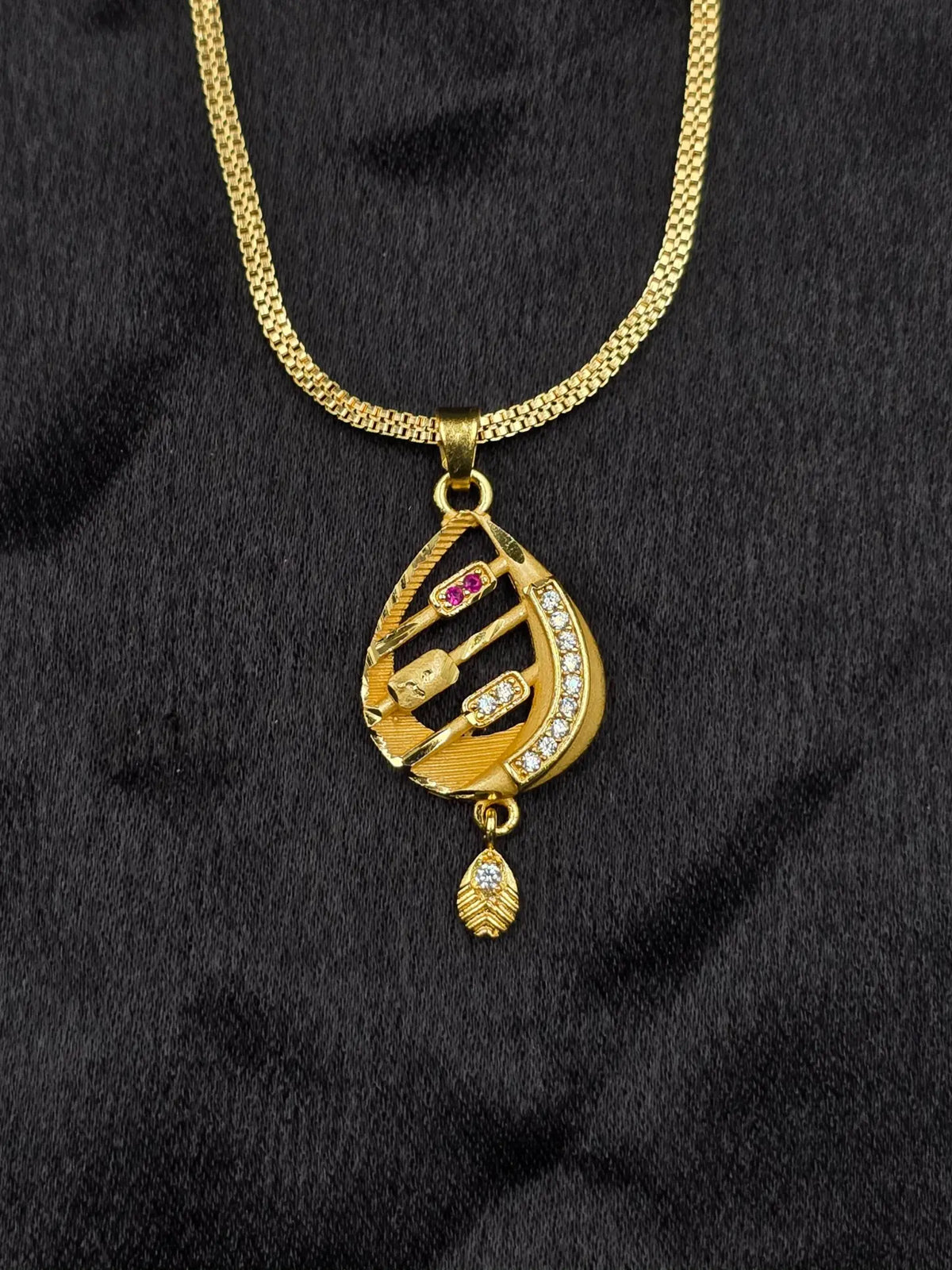 Gold necklace with a pendant on a black fabric background