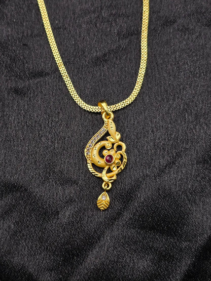 Gold necklace with a decorative pendant on a black fabric background