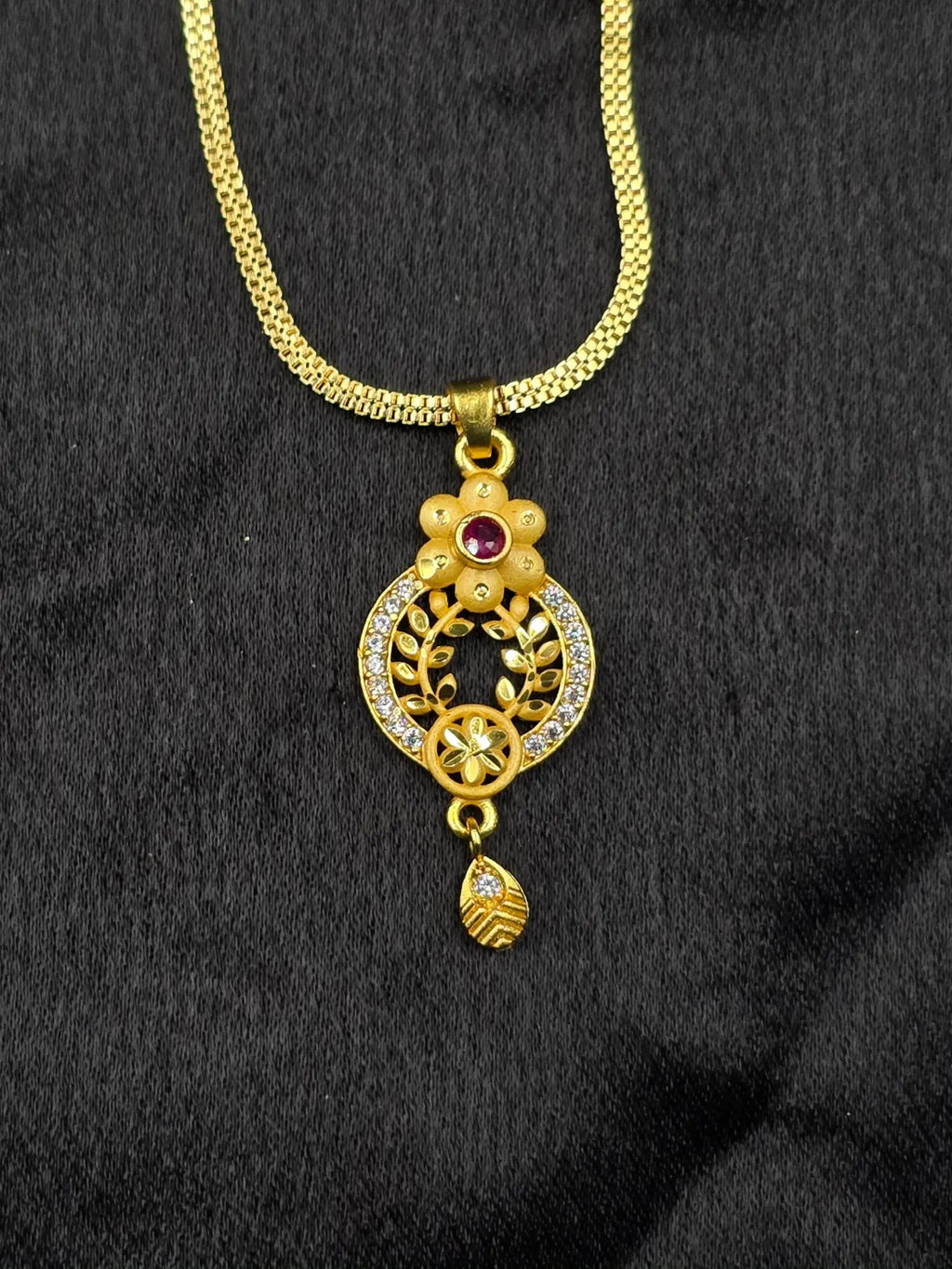 Gold necklace with a decorative pendant on a black background