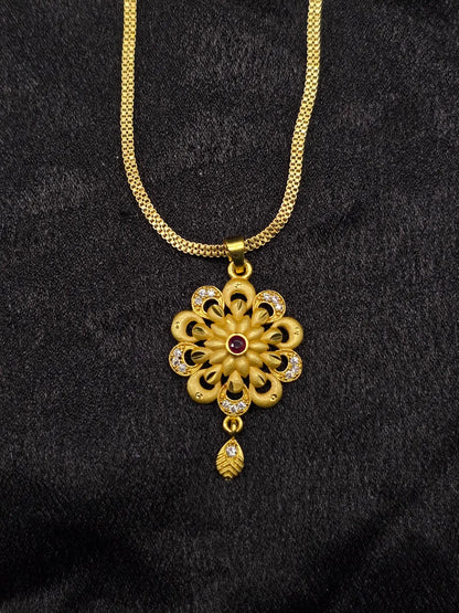 Gold necklace with a floral pendant on a black background