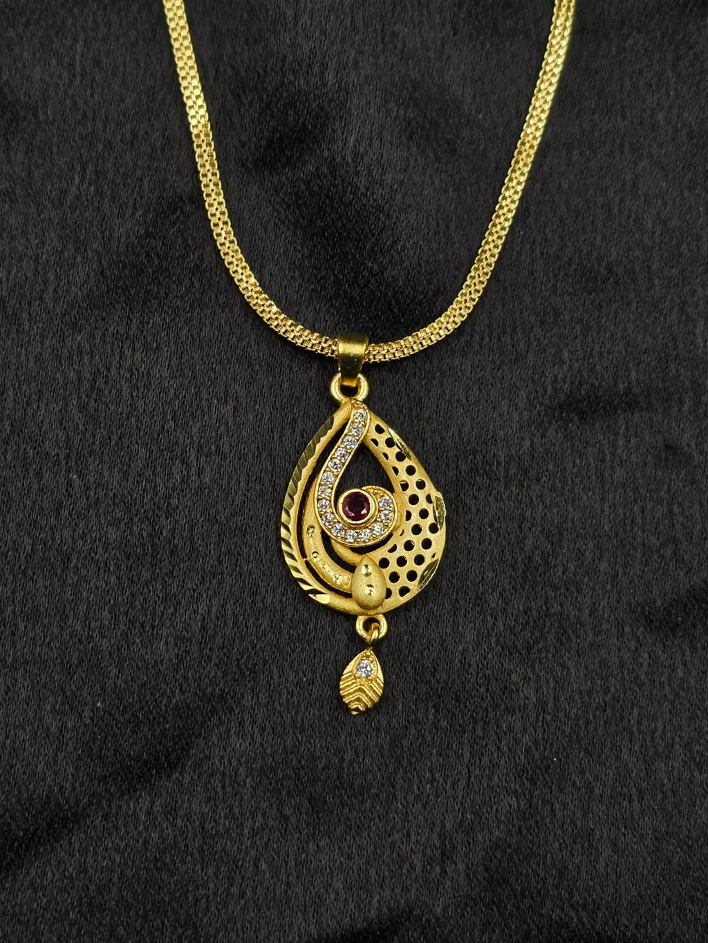 Gold necklace with a pendant on a black fabric background