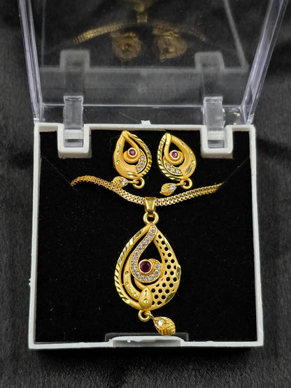 Gold necklace and earrings set in a clear display case on a black background