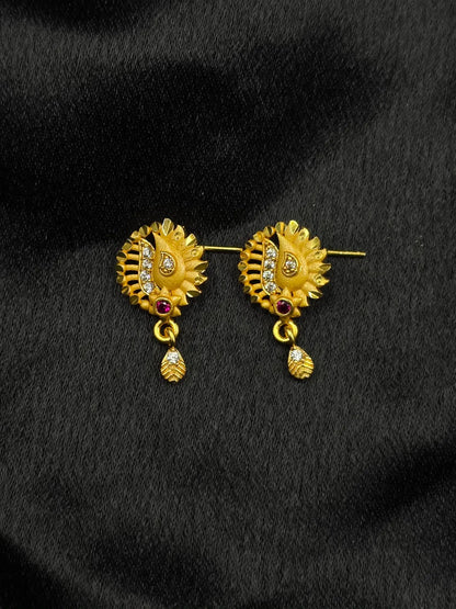 Gold earrings with gemstones on a black background