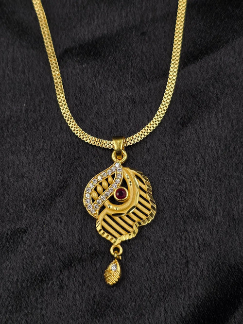 Gold necklace with a pendant featuring a red gemstone on a black background