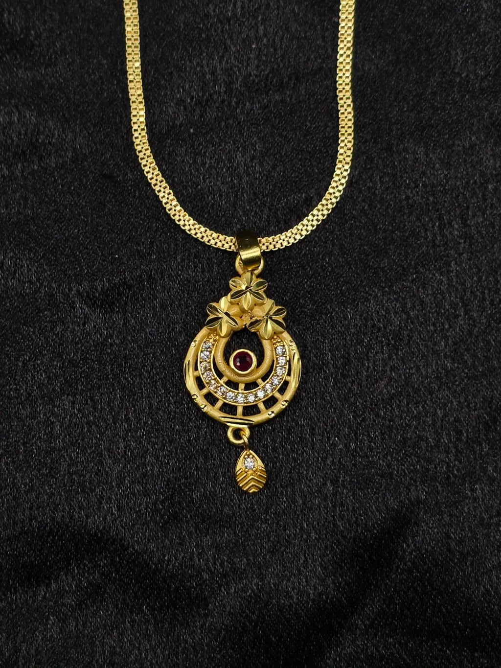 Gold necklace with a pendant on a black background