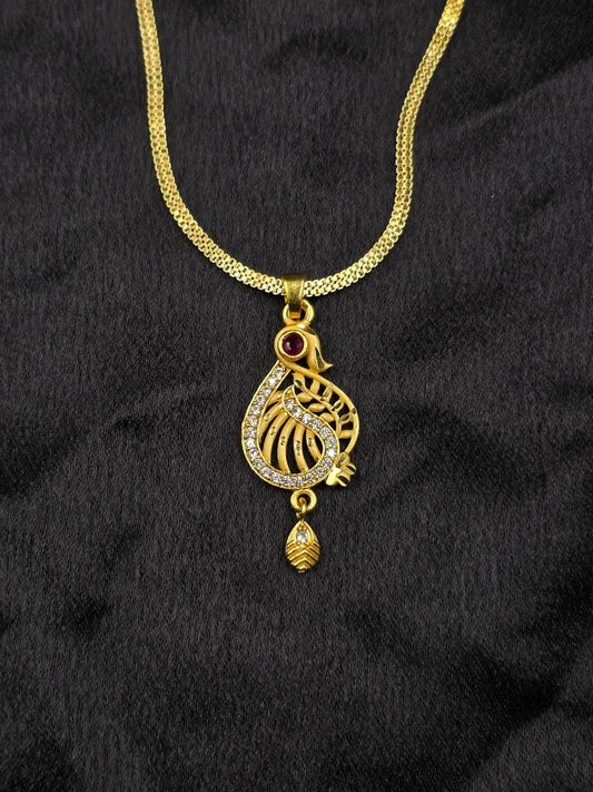 Gold necklace with a decorative pendant on a black fabric background