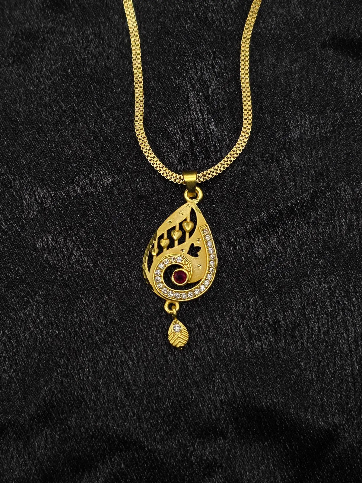 Gold necklace with a pendant on a black background