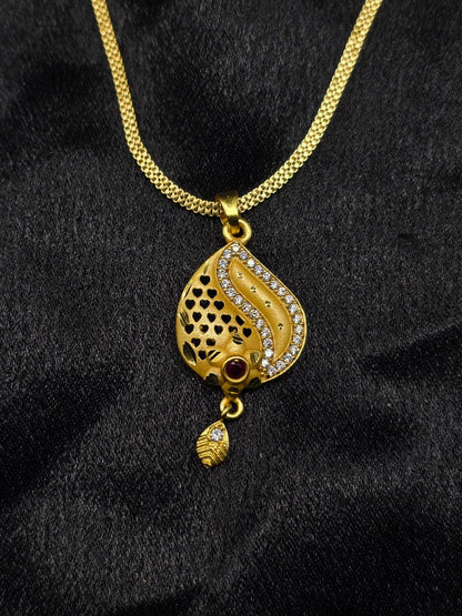 Gold necklace with a detailed pendant on a black fabric background