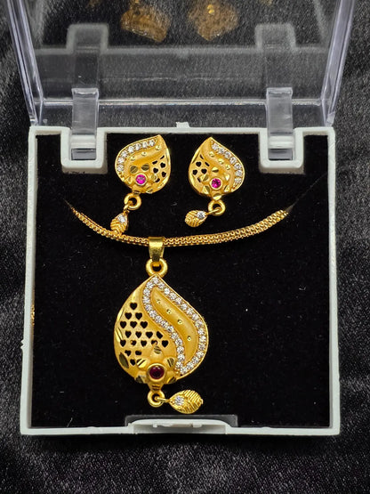 Gold necklace and earrings set in a clear display case on a black background