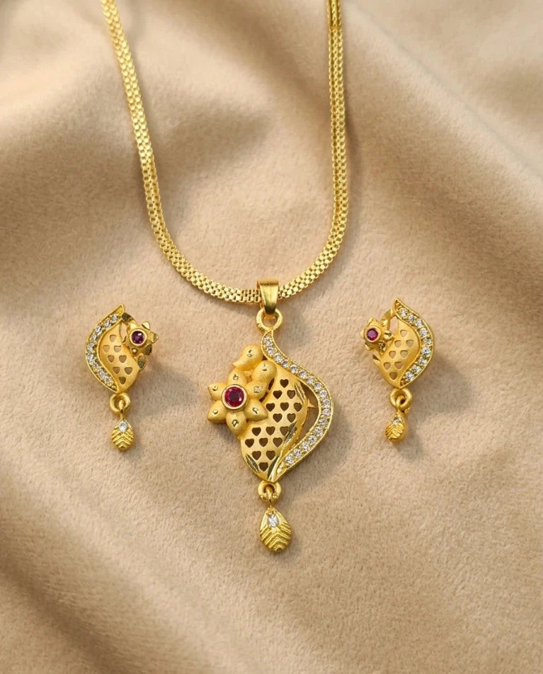 Gold necklace with matching earrings on a beige fabric background