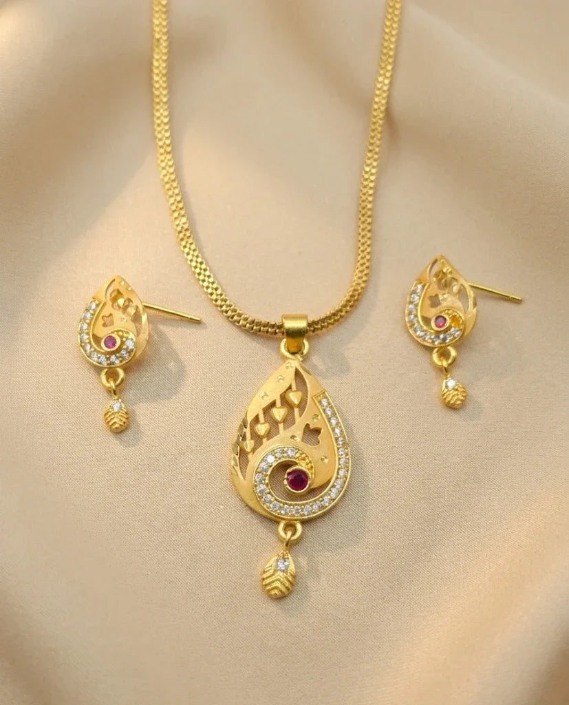 Gold necklace and earrings set on a beige background