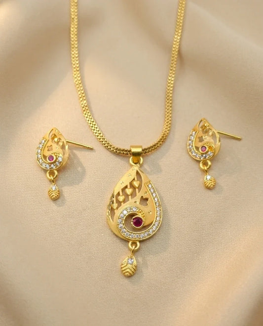 Gold necklace and earrings set on a beige background