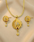 Gold necklace and earrings set on a beige background