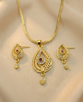 Gold necklace and earrings set on a beige background