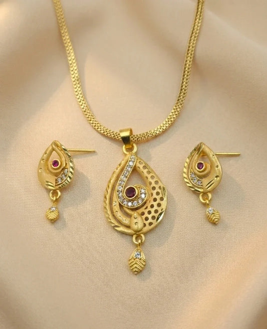 Gold necklace and earrings set on a beige background
