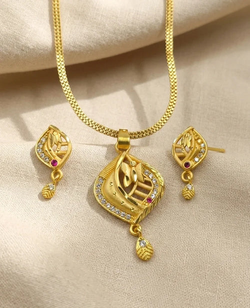 Gold necklace and earrings set on a beige fabric background