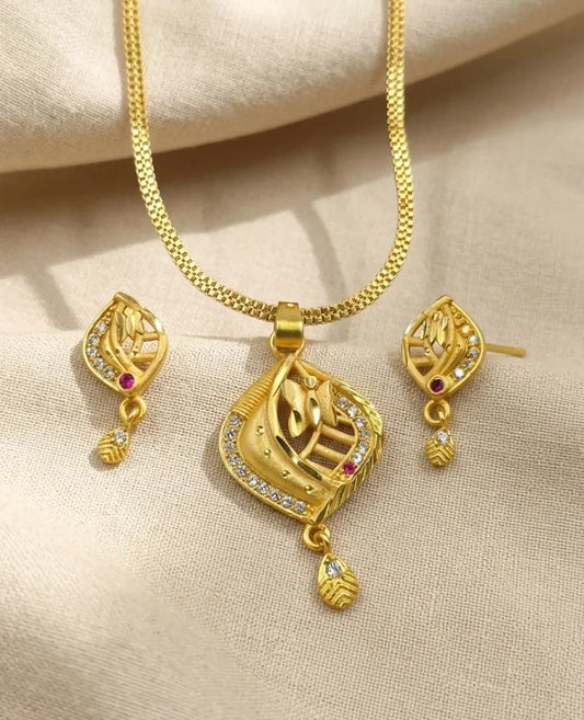 Gold necklace and earrings set on a beige fabric background