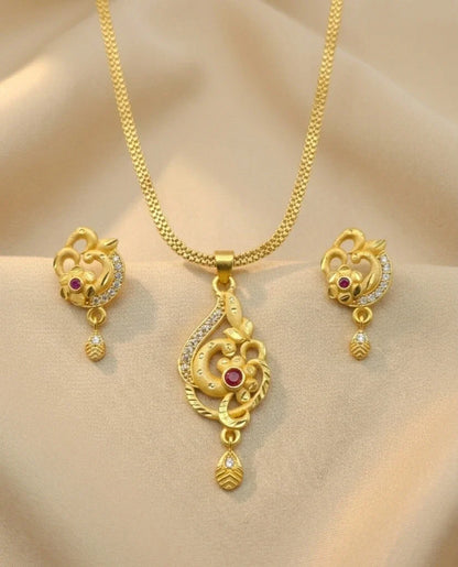 Gold necklace set with pendant and earrings on a beige background