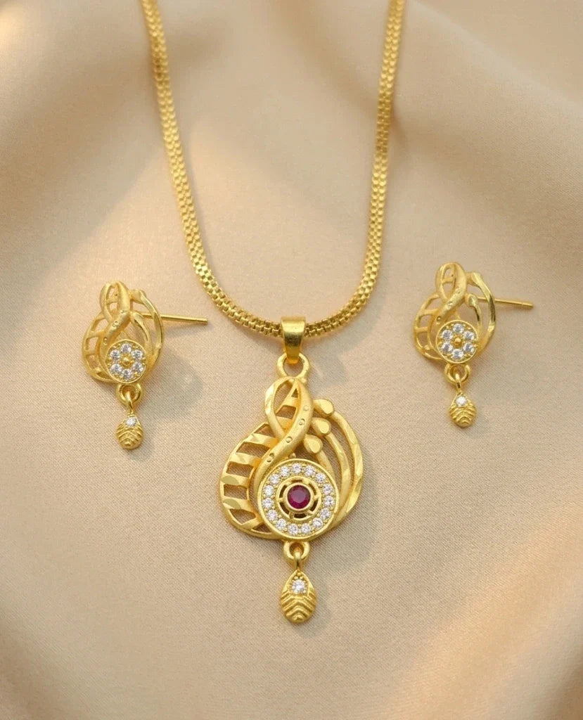 Gold necklace and earrings set on a beige background