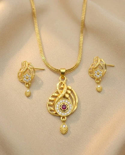 Gold necklace and earrings set on a beige background