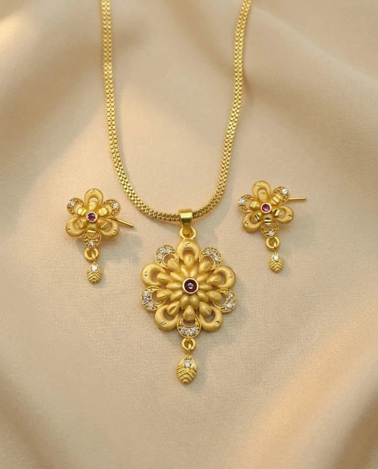 Gold necklace and earrings set on a beige background
