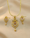Gold necklace and earrings set on a beige fabric background