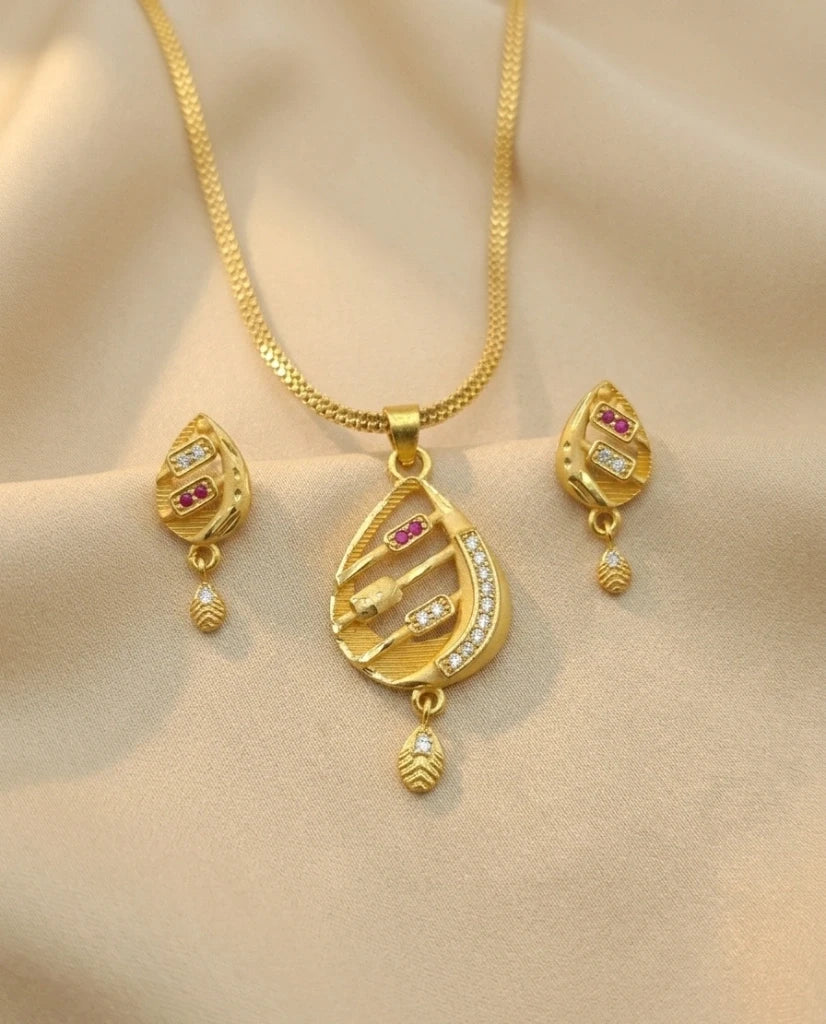 Gold necklace and earrings set on a beige background
