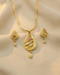 Gold necklace and earrings set on a beige background