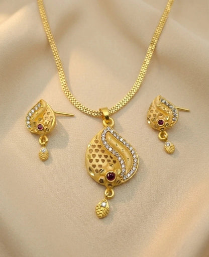 Gold necklace and earrings set on a beige background