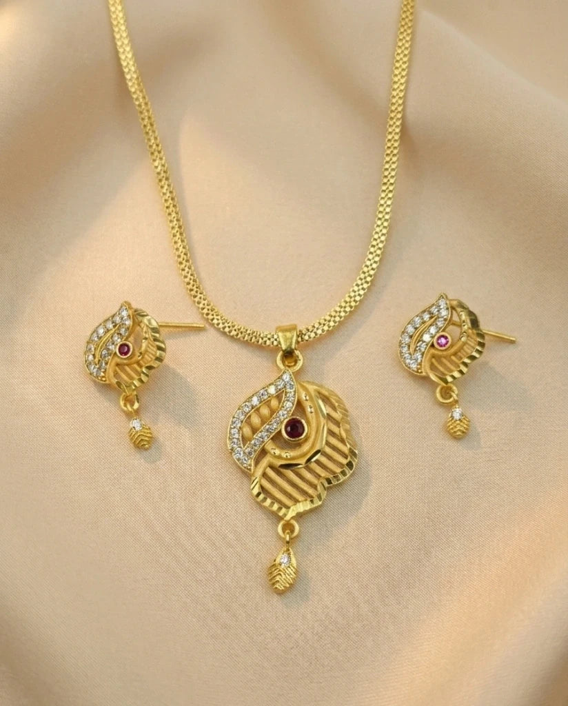 Gold necklace and earrings set on a beige background
