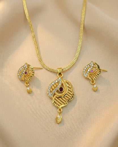 Gold necklace and earrings set on a beige background