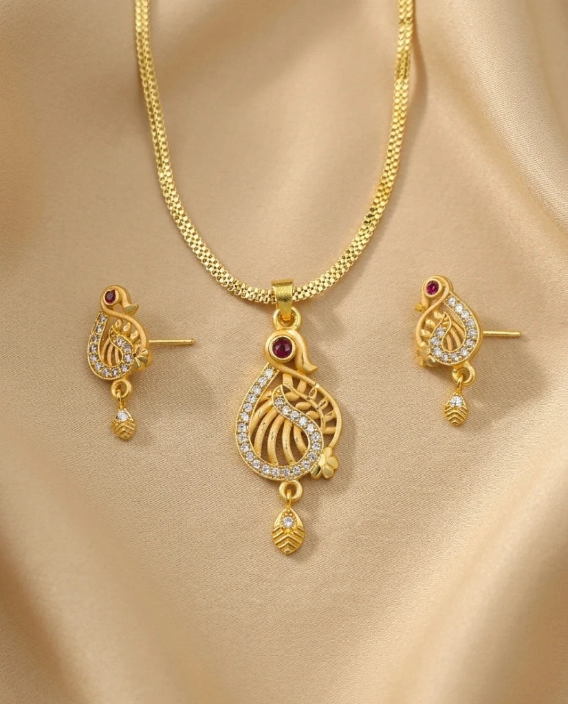 Gold necklace and earrings set on a beige fabric background