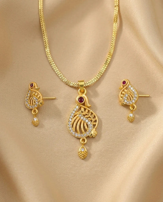 Gold necklace and earrings set on a beige fabric background