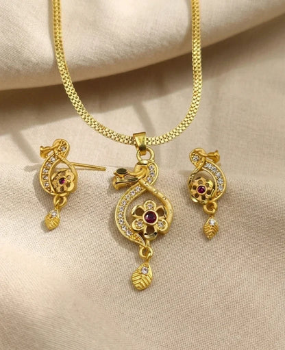 Gold jewelry set with necklace and earrings on a beige fabric background