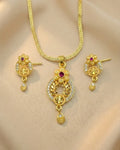 Gold necklace and earrings set on a beige background