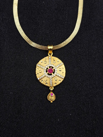 Gold necklace with a decorative pendant on a black background